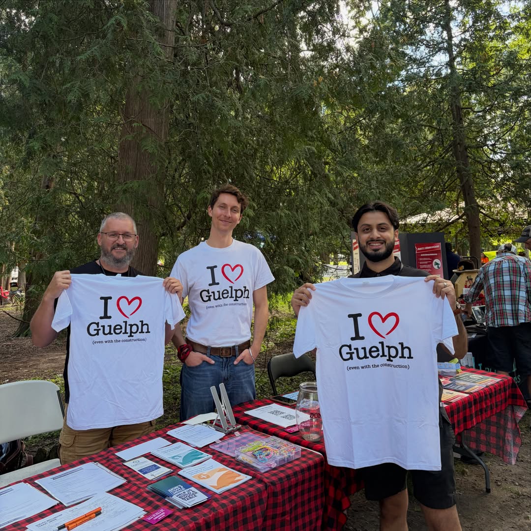 Mustafa Zuberi holding I Love Guelph shirts at a local event